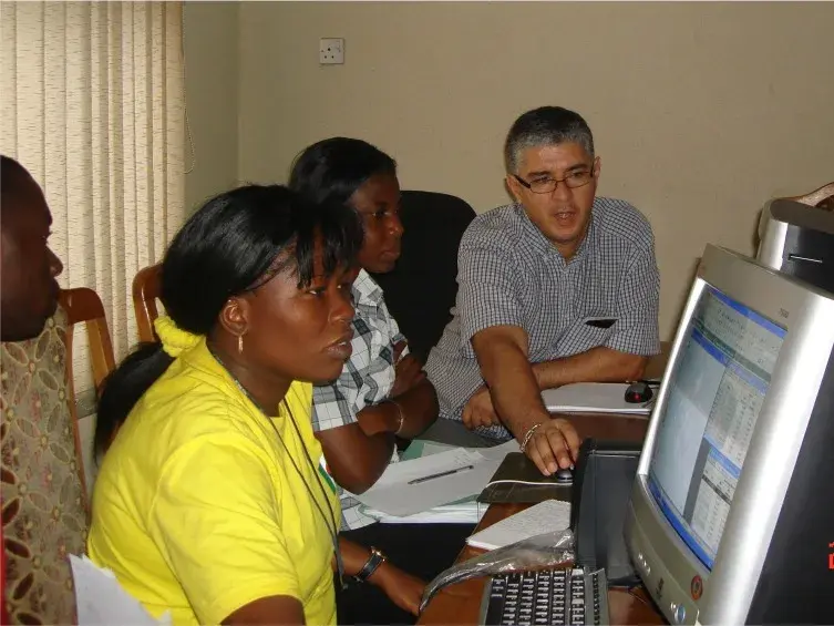 An instructor guiding consulting staff through CivilCAD at a computer workstation